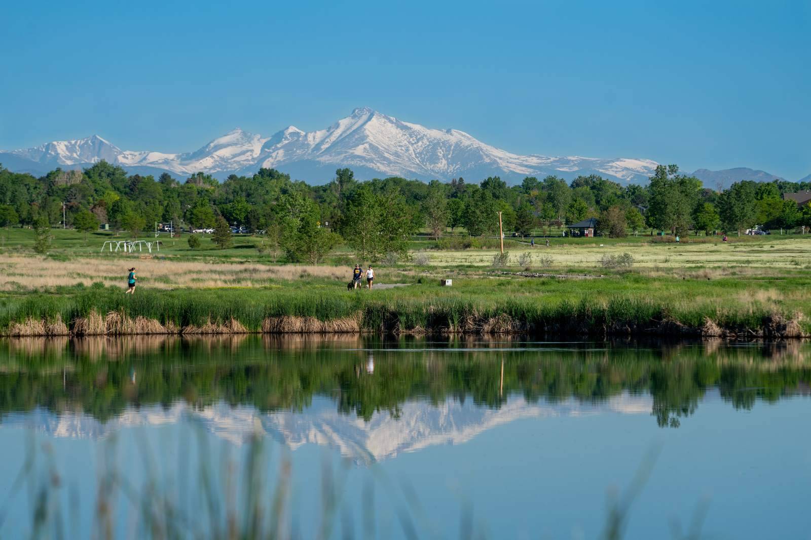 A mountain lake in Colorado with snow on the peaks behind it